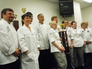 Team Anne Arundel, the culinary competition team of the Hotel, Culinary Arts and Tourism Institute at Anne Arundel Community College, took second place in the 6th Annual Chesapeake Culinary Cup competition held recently at Anne Arundel Community College’s Hotel, Culinary Arts and Tourism Institute in Glen Burnie. Carrie Svoboda of Stevensville is holding the second-place trophy. From left are Chef David Ludwig, CEPC, CHE, Team Anne Arundel coach; Elena Clement, CEPC, judge; Ricky Rice of Pasadena; Chef John Johnson, CEC, CCE, AAC, Team Anne Arundel coach; Svoboda; Michael Willard of Annapolis; Erin Gregory of Edgewater; Brian Campbell, CEC, judge; Jennifer Lowe of Stevensville; Mikey Beriau, CEC, AAC, judge; and Gunther Heiland, CMPC, AAC.