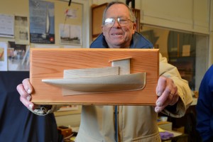 CBMM Model Guild President and volunteer Bob Mason holds an example of the half-hull model that will be made during a March 28 & 29 weekend workshop for participants 12 years of age and older. The beginner’s workshop includes instruction on carving a solid half model of the historic Chesapeake Bay tugboat Delaware. This model is band-sawed from a two-tone wood block and carved to the rounded shape of the Delaware’s hull. The cabin and pilot house are cut from the same pieces. The pieces are then shaped and sanded to a fine finish and then mounted on a baseboard to form a wall display piece that goes home with participants at the end of the workshop. To register or for more information, email aspeight@cbmm.org or call 410-756-2916. 