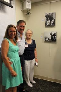 The family of Tribute Wall honoree Donald Green pose by his photo, which is marked as number 10 on the wall. They are, pictured from left, Mary, Mike and Betty Green.