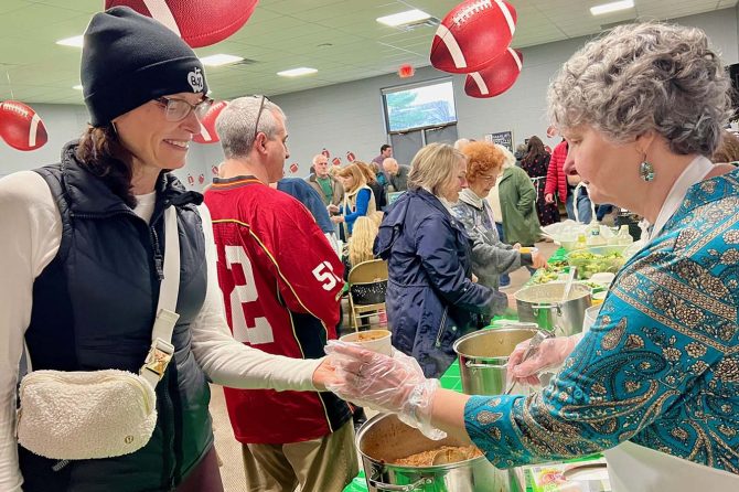 Volunteer Ketta Hannon of Annapolis serves chili to Jennifer Pope, also of Annapolis, at Heritage Baptist’s 18th Annual SOUPer Bowl Lunch for the Light House Homeless Prevention Center.